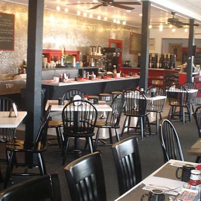 Inside the Daily Paper, black, homestyle chairs, clean tables, red counter seating, coffee mugs