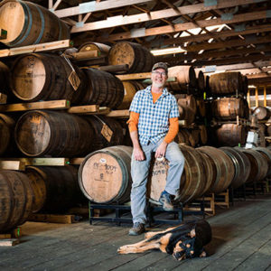 Distiller, dog and barrels at triple eight distillery