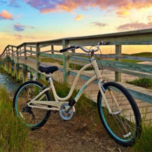 bike in front of boardwalk at sunset