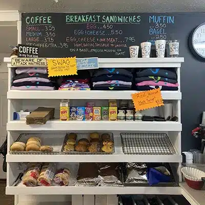Picnic basket counter display with bagels, muffins, cereal and swag