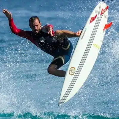 Surfer spinning in air above a wave