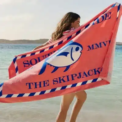 Woman holding Southern Tide towel at the beach